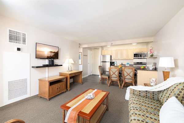 Living room with mountain and city views, dining area, desk, and pull-out sleeper sofa, flat screen TV