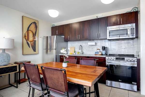 Dine in style! Enjoy meals at the beautiful live-edge wooden table right next to your modern kitchen with granite counters and stainless steel appliances.