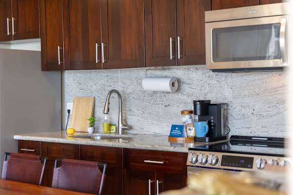This beautifully appointed kitchen features modern stainless steel appliances, granite countertops, and rich cabinetry.