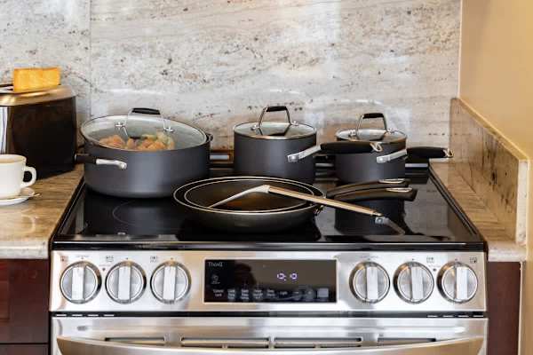 Featuring a sleek stovetop and a complete set of pots and pans for effortless cooking.