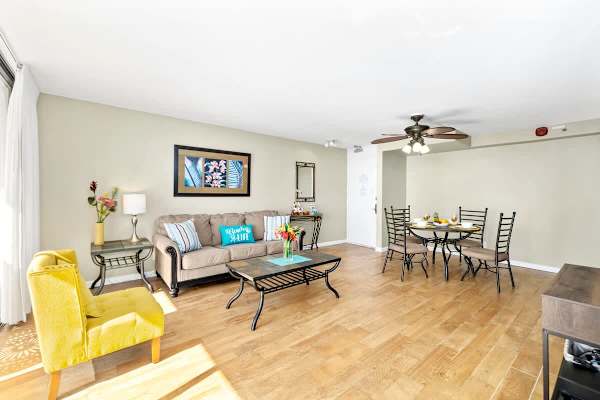 Living room with pull our sofa couch, ceiling fan and cable TV
