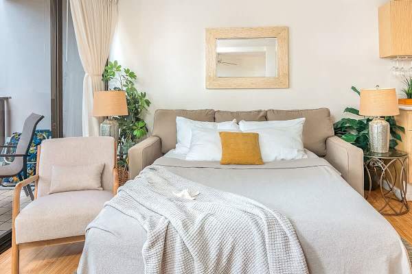 Pull-out sleeper sofa in the living room with coffee table, 2 nightstands, and armchair.