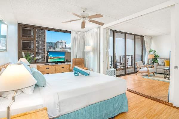 Your bedroom with a queen-size bed, nightstands, ceiling fan, flat-screen TV, and sliding door that separates from the living room.