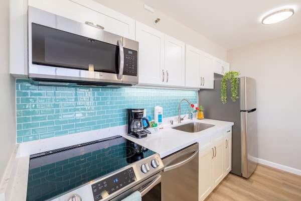 Kitchen with dishwasher, cooktop stove, microwave and fridge