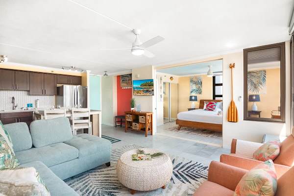 Your living room has a new sectional pull-out sleeper sofa, a new rattan round coffee table, 2 armchairs, and a smart TV.