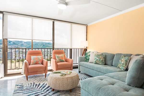 Living room with new sectional pull-out sleeper sofa, rattan round coffee table, and 2 accent chairs.