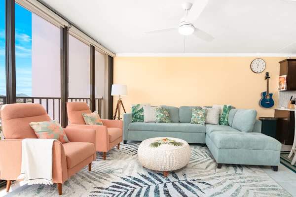 Living room with new sectional pull-out sleeper sofa, rattan round coffee table, and 2 accent chairs.