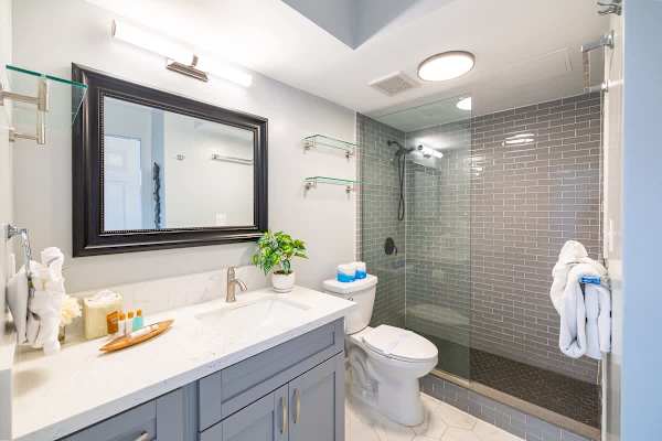 Modern bathroom with a glass-enclosed shower and marble countertop.