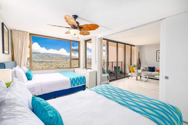 Bright bedroom with city and mountain views and a connected living area.