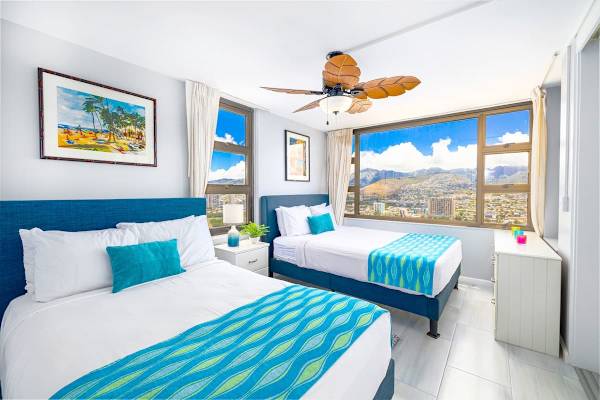 Bright bedroom with two queen beds and panoramic city and mountain views