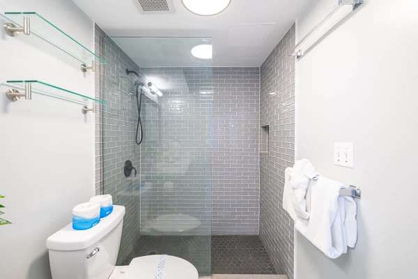 Modern bathroom with a walk-in shower featuring gray subway tiles and hexagonal floor tiles.