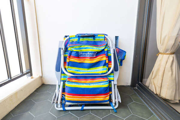 Folded colorful beach chairs stored on the balcony with tiled flooring.