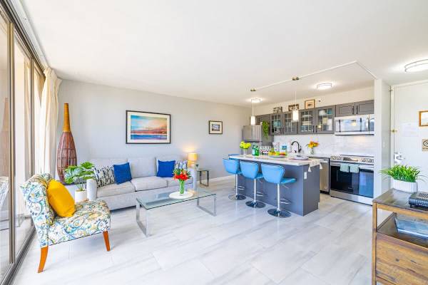 Bright open-concept living area with a modern kitchen island and seating for four.