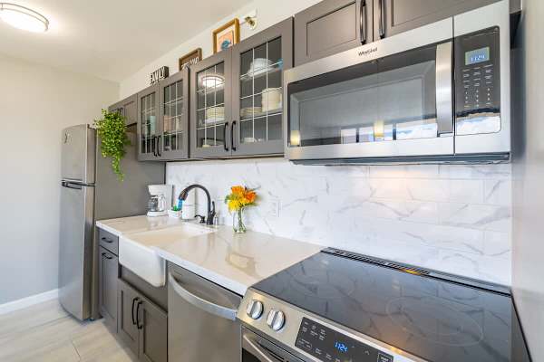 Modern kitchen with stainless steel appliances and glass-front cabinets