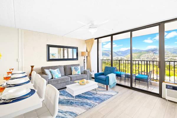 The living room has a ceiling fan, a pullout sleeper sofa, a coffee table, a chair, window AC, and a flat-screen TV!