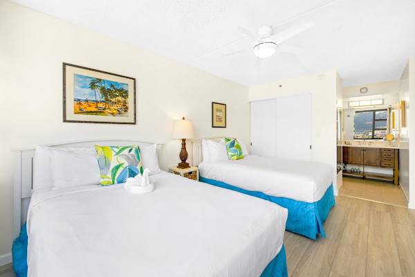 The bedroom has a ceiling fan, 2 queen-size beds, dresser, closet, and nightstand.