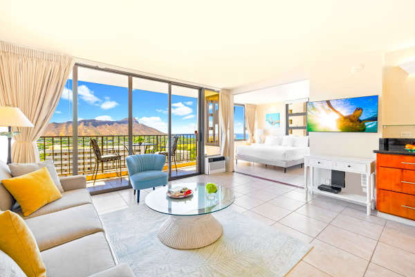 Bright living area with mountain views and access to a balcony seating area.