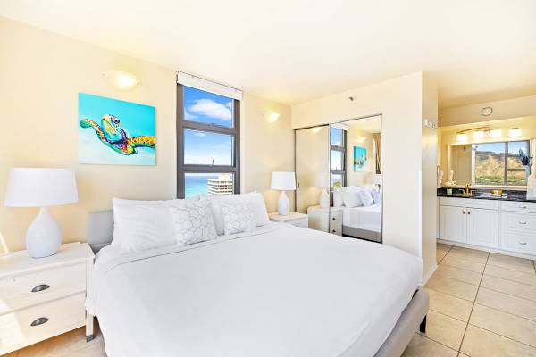 Bright bedroom with ocean and mountain views and modern decor