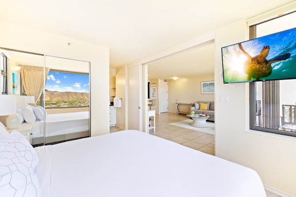 Bright bedroom with mountain views and a wall-mounted television