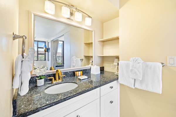 Modern bathroom vanity with granite countertop and gold fixtures