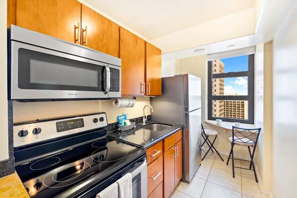Compact kitchen with modern appliances and a city view breakfast nook.