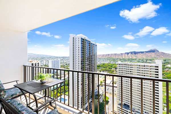 Enjoy city and mountain views from this high-rise balcony with seating.