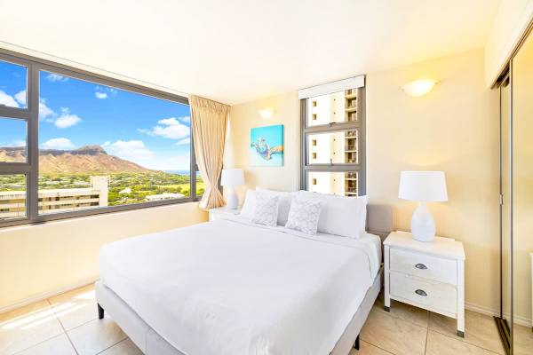 Bright bedroom with large windows offering mountain views.