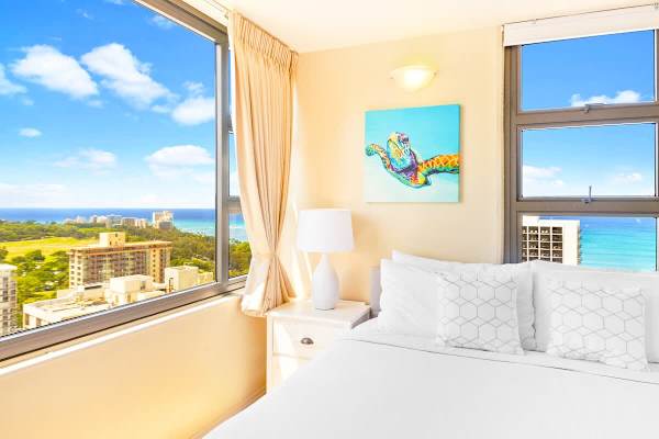 Bright bedroom with ocean views and colorful turtle artwork