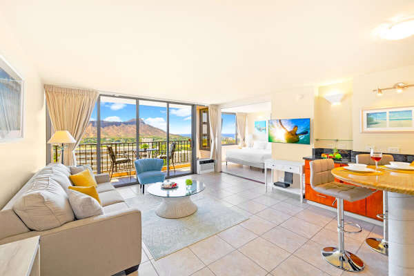 Bright living area with mountain views and access to a balcony seating area.