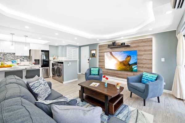 The living room has a flat screen TV, queen-size sleeper sofa, coffee table, and 2 chairs perfect for relaxation!