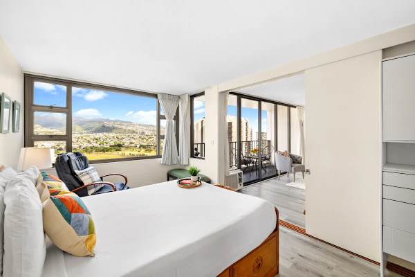Bedroom with a queen-size bed. Bedroom has a sliding door that separates it from the living room.