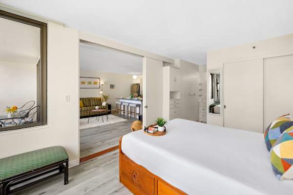 Bedroom with a queen-size bed. Bedroom has a sliding door that separates it from the living room.