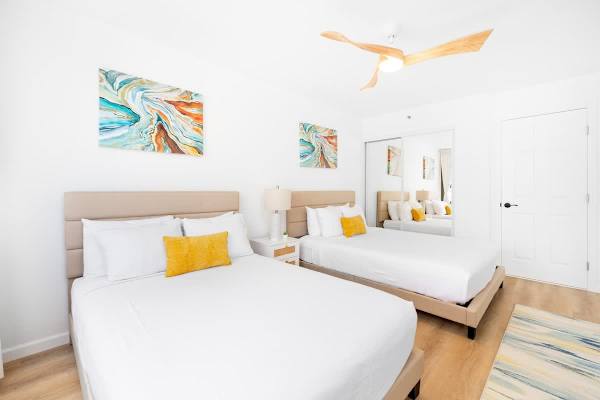 The bedroom features a queen-size and a full-size bed, closet, a nightstand, and a ceiling fan with light.