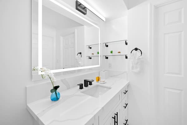 The bathroom has a vanity with cabinets.