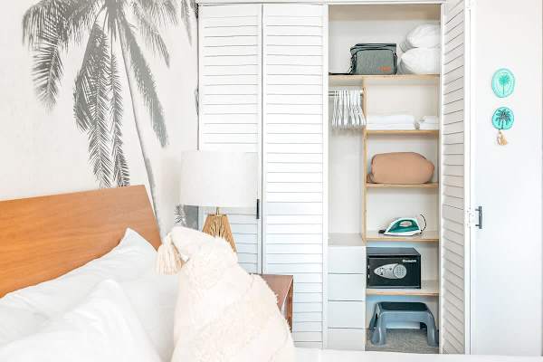 Closet with towels and other bedroom stuffs.