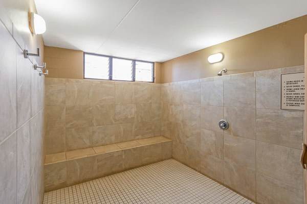 Rinse off before or after a sauna session in the fully tiled, spacious shower area with built-in bench seating.