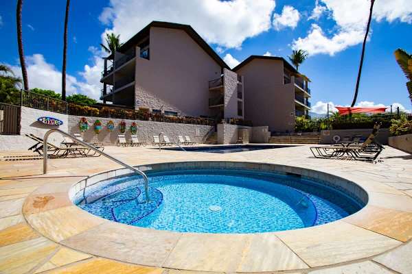 Soak in relaxation at the hot tub and swimming pool area, complete with comfortable loungers and tropical resort surroundings.