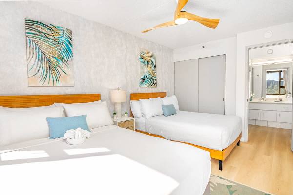 Bedroom with 1 queen-size and 1 full-size bed and a dresser.