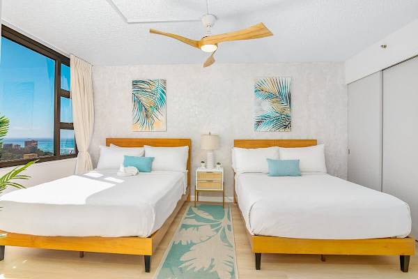 Bedroom with 1 queen-size and 1 full-size bed and a dresser.