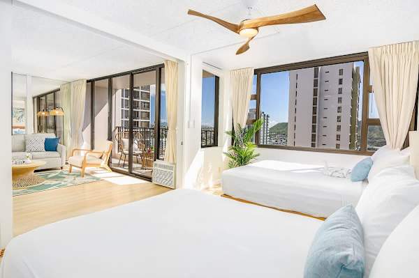 Bedroom with a sliding door that separates from the living room for privacy, and a fan.