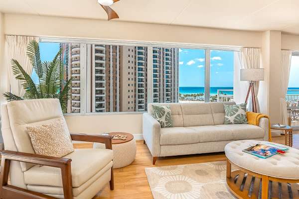 A very spacious living area with pull-out sleeper sofa, coffee table, chair, and beautiful ocean view. 