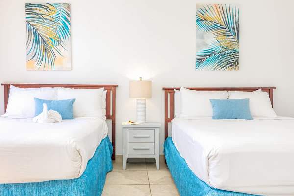 Bedroom with 1 queen-size and 1 full-size bed, and nightstand.