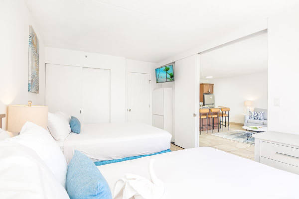 Bedroom with 1 queen-size and 1 full-size bed, dresser, and access to the bathroom, and sliding door that separates from the living room.