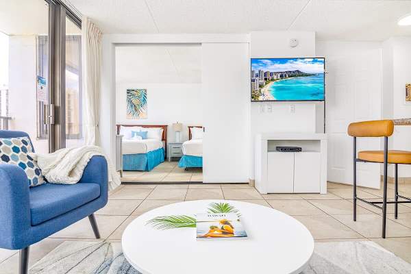 Spacious living room with pull-out sleeper sofa, flatscreen TV, coffee table, and chair.