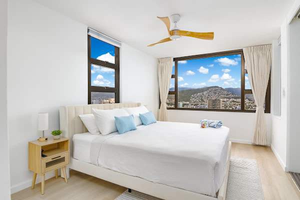 A tranquil bedroom retreat featuring a comfortable king-size bed and stunning panoramic views of the mountains, inviting you to wake up to a breathtaking scene every day.