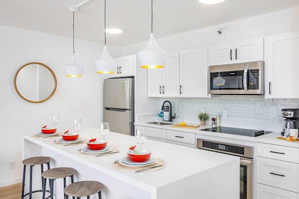 Cook in style in this fully-equipped, modern kitchen, featuring a spacious eat-in bar and sleek stainless steel appliances.