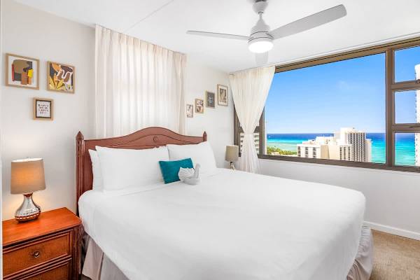 Bedroom with king-size bed, ceiling fan, and closet perfect for relaxation.