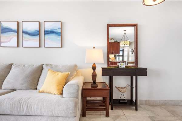 A lamp and console table with a mirror in the living room.