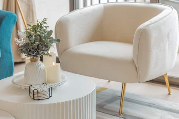 A nomad round coffee table, and accent chair in the living room.