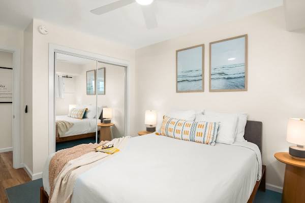 The second bedroom with a queen-size bed, closet, and a ceiling fan.